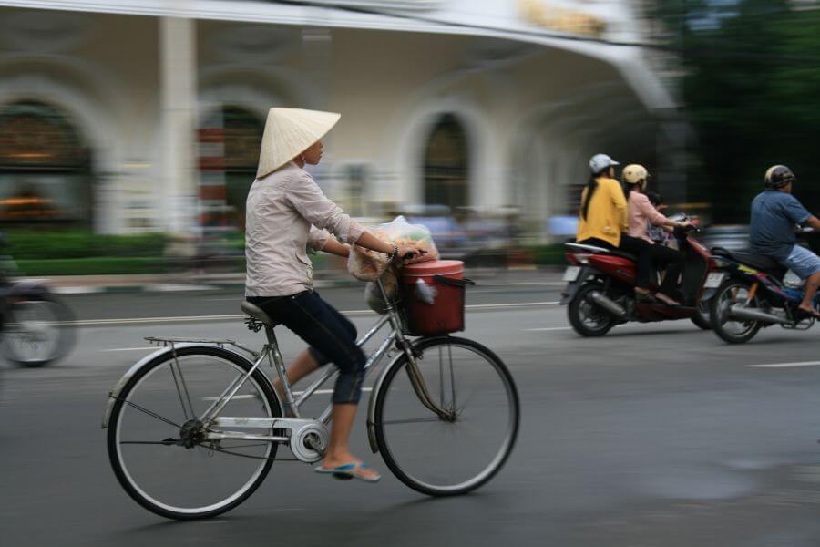 Vietnam - Hanoi - Vrouw op Fiets druk verkeer